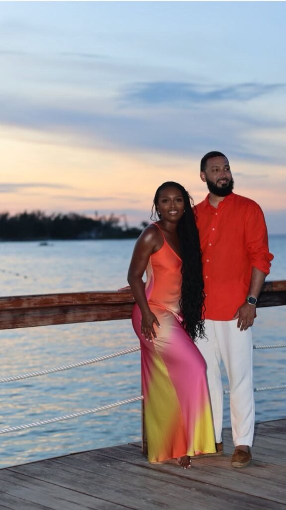 Black couple in coordinated red and navy outfits on vacation at sunset