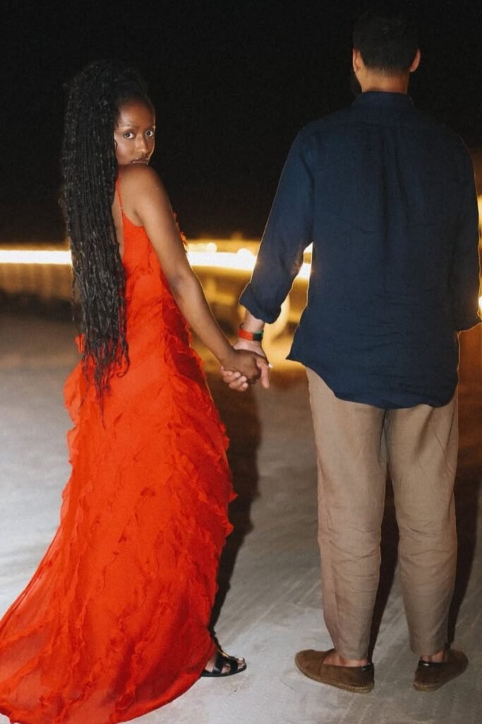 Coordinated red maxi dress and navy shirt for a stylish couple's vacation dinner look