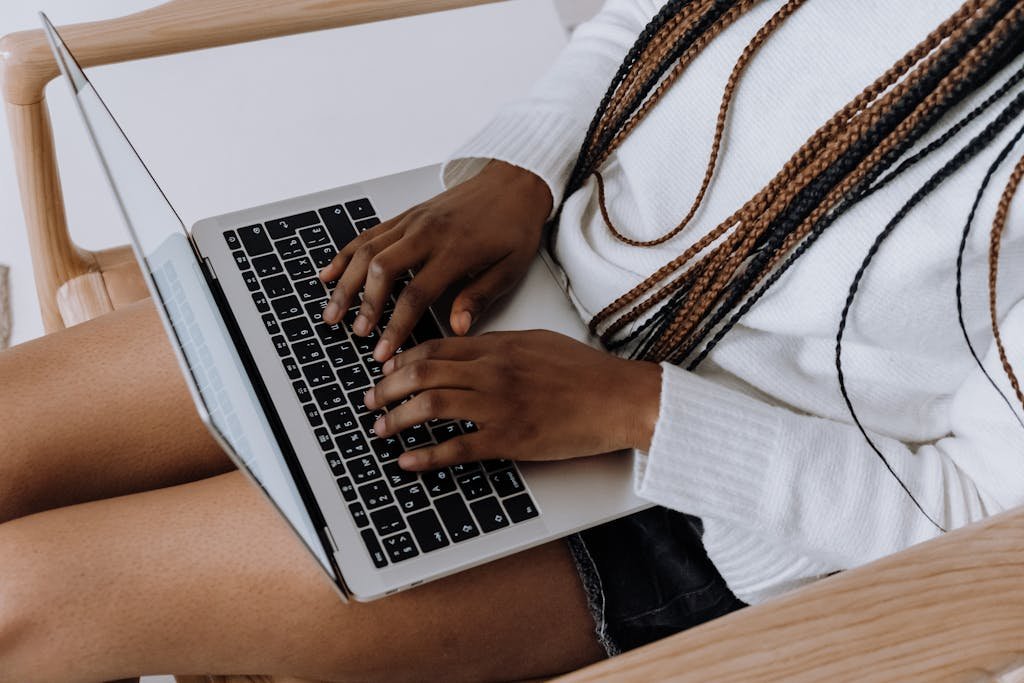 Person typing on a laptop indoors, showcasing modern technology and lifestyle.